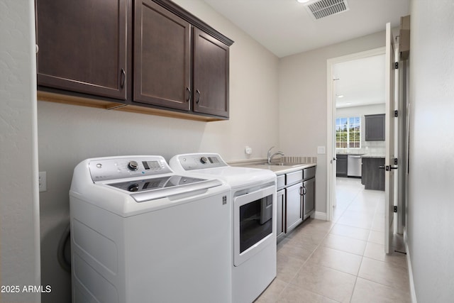 20644 W Mariposa St, Buckeye, AZ 85396 - laundry area featuring washer and dryer, cabinet space, light tile patterned floors, and baseboards