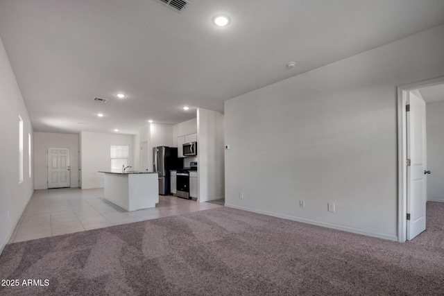 unfurnished living room with sink and light colored carpet