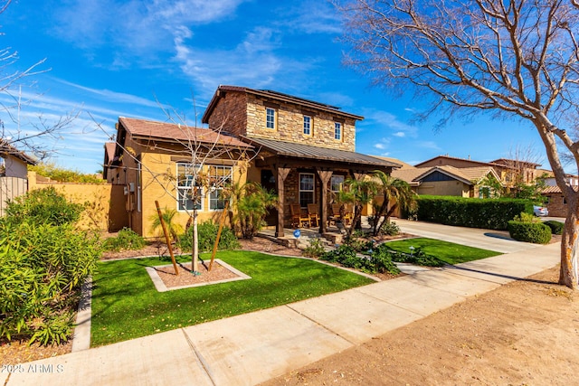 view of front of home with stone siding, metal roof, a standing seam roof, fence, and a front lawn