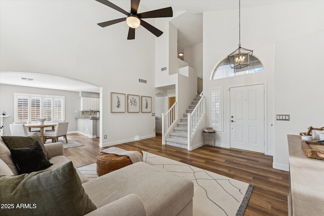 10252 E Butherus Dr, Scottsdale, AZ 85255 - living room featuring stairs, wood finished floors, a high ceiling, ceiling fan, and arched walkways