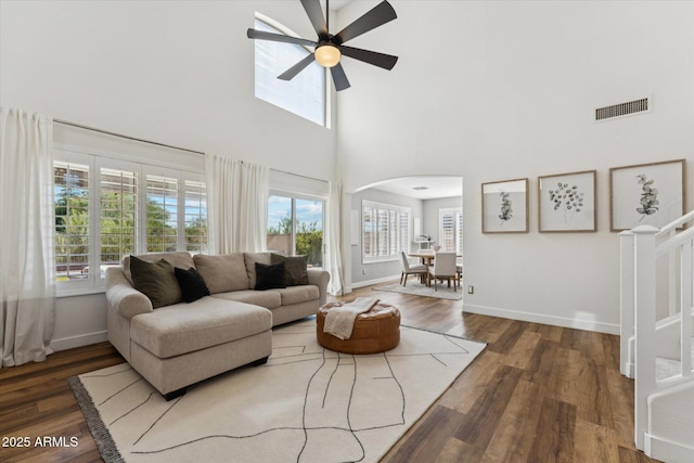 10252 E Butherus Dr, Scottsdale, AZ 85255 - living room featuring arched walkways, a towering ceiling, a ceiling fan, and wood finished floors