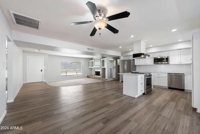 kitchen with dark hardwood / wood-style floors, decorative backsplash, stainless steel appliances, and white cabinets