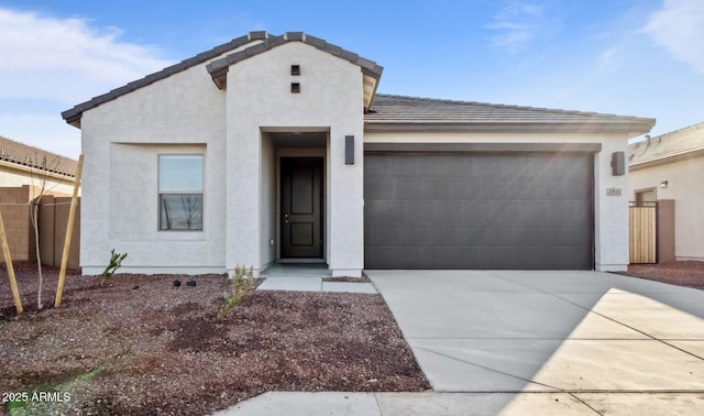 view of front facade featuring fence, stucco siding, concrete driveway, a garage, and a tile roof