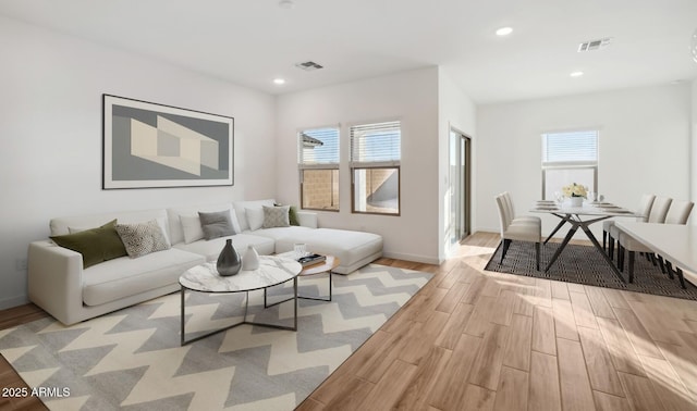 living area featuring recessed lighting, visible vents, baseboards, and light wood finished floors