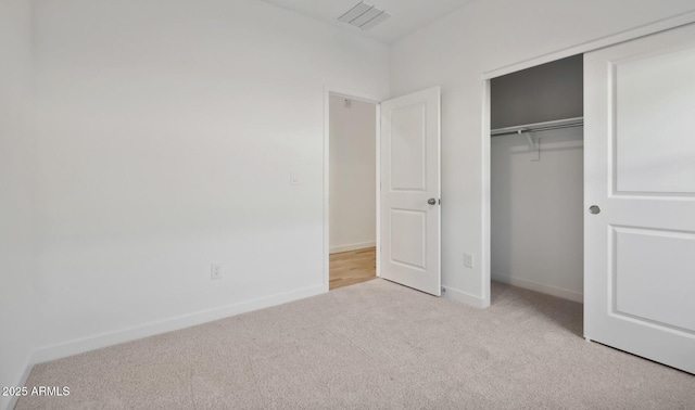 unfurnished bedroom with a closet, carpet flooring, visible vents, and baseboards