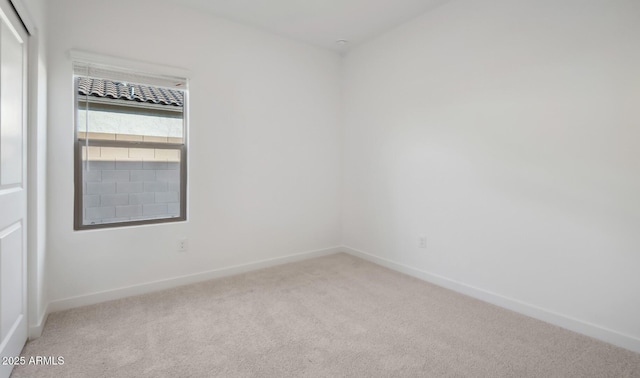 carpeted spare room featuring baseboards