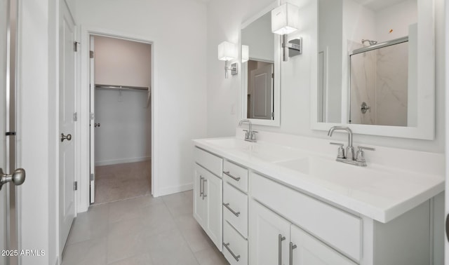 full bathroom featuring a sink, a marble finish shower, double vanity, and tile patterned flooring