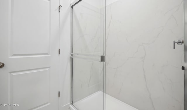 bathroom with a marble finish shower