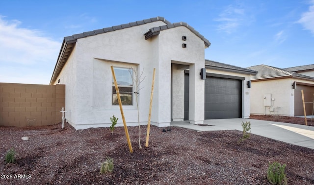 view of front of home featuring a tile roof, stucco siding, an attached garage, and concrete driveway