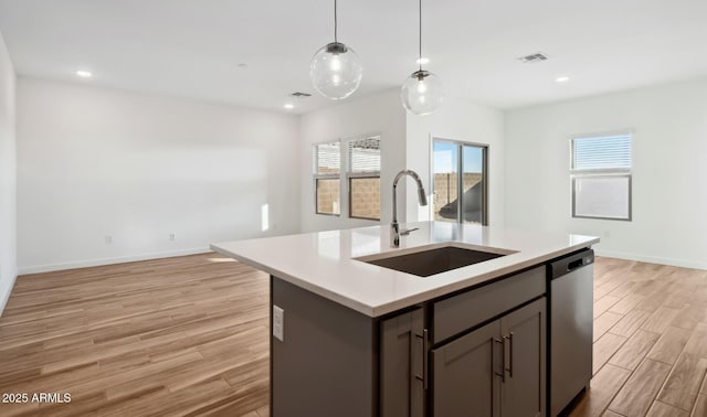 kitchen with visible vents, light wood finished floors, a sink, light countertops, and dishwasher