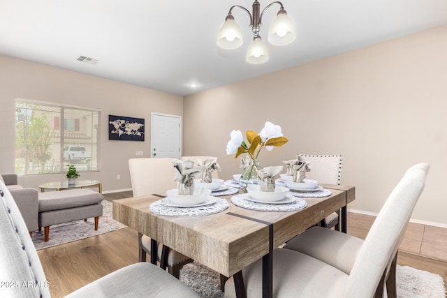 dining area featuring light hardwood / wood-style flooring and an inviting chandelier