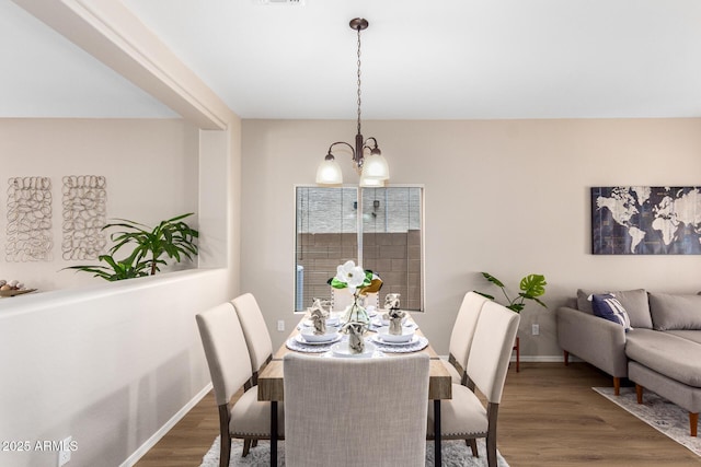 dining area featuring dark hardwood / wood-style flooring and an inviting chandelier