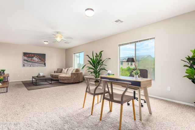 carpeted dining area with ceiling fan