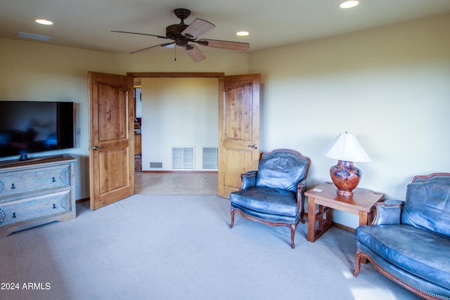 sitting room featuring light colored carpet and ceiling fan