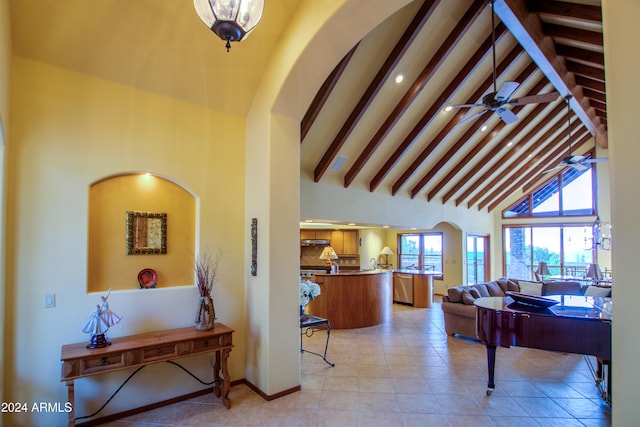 interior space featuring beamed ceiling, high vaulted ceiling, ceiling fan, and light tile patterned flooring