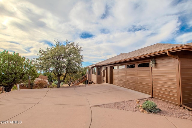 6641 W Wolfpaw Ln, Pine, AZ 85544 - view of side of home with driveway, stairs, an attached garage, and roof with shingles