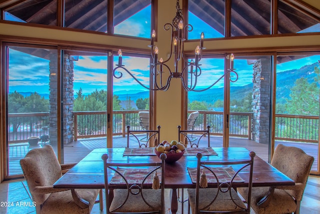 dining space featuring a mountain view, tile patterned flooring, high vaulted ceiling, and plenty of natural light