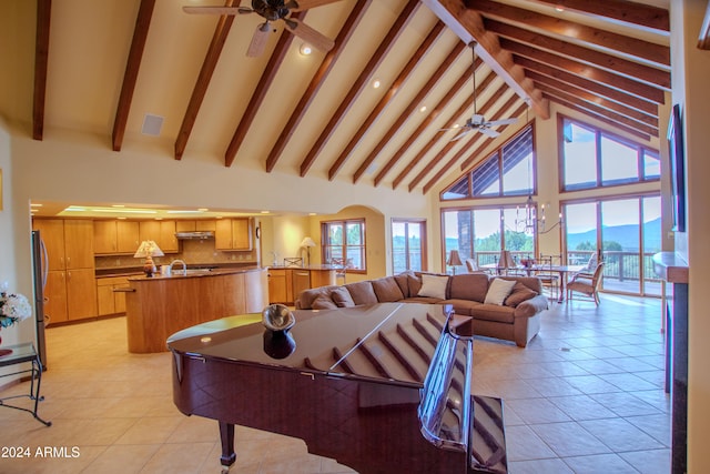 living room featuring beamed ceiling, ceiling fan with notable chandelier, high vaulted ceiling, and light tile patterned flooring