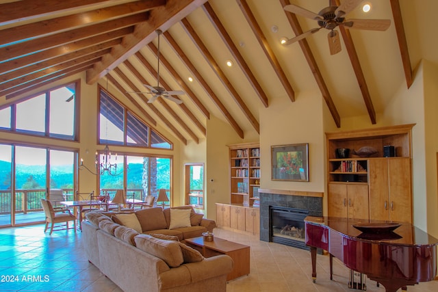 living room with beam ceiling, ceiling fan with notable chandelier, high vaulted ceiling, and a tiled fireplace