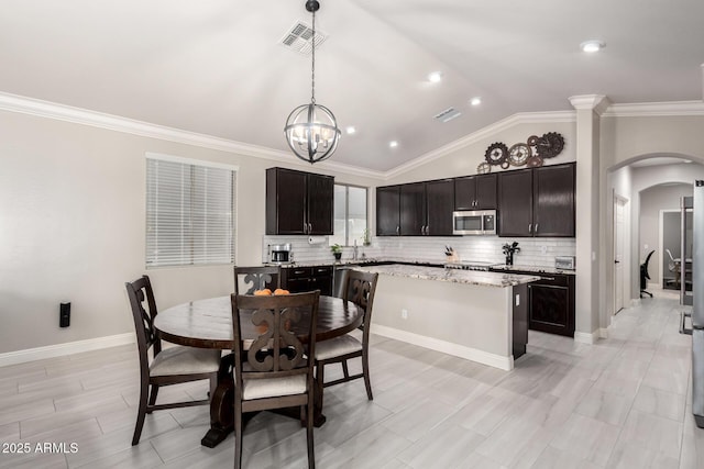 dining space with an inviting chandelier, visible vents, arched walkways, baseboards, and vaulted ceiling