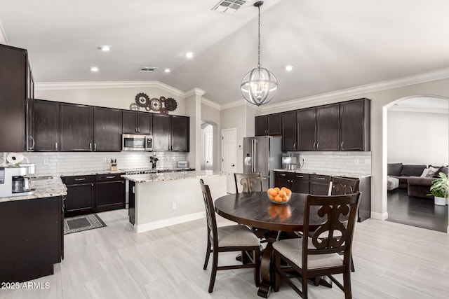 dining room featuring an inviting chandelier, arched walkways, and visible vents