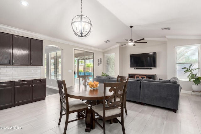 dining room featuring visible vents, arched walkways, vaulted ceiling, baseboards, and ceiling fan with notable chandelier