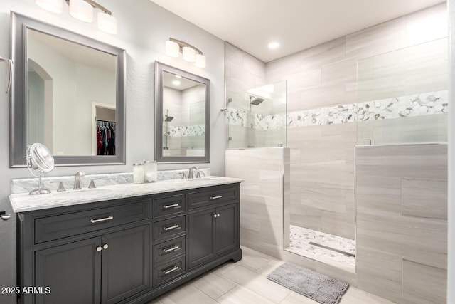 full bath featuring a sink, a walk in shower, tile patterned flooring, and double vanity