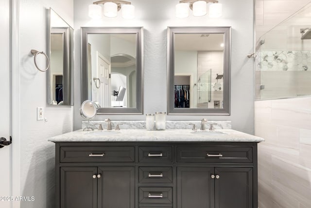 full bath with double vanity, a sink, and a stall shower