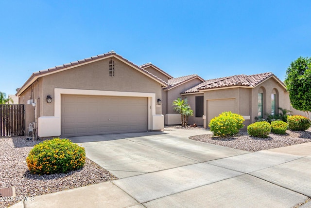 view of front of house with an attached garage, stucco siding, driveway, and a tile roof