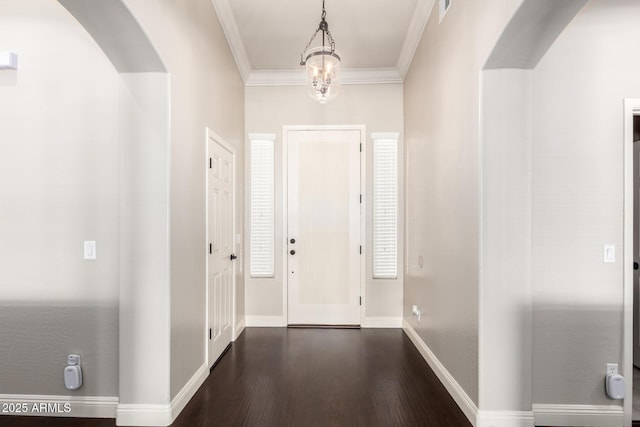 foyer featuring crown molding, visible vents, baseboards, dark wood-style floors, and arched walkways