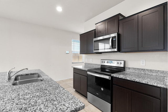 5269 E Gummite Dr, San Tan Valley, AZ 85143 - kitchen featuring light tile patterned floors, stainless steel appliances, a sink, light stone countertops, and dark brown cabinetry