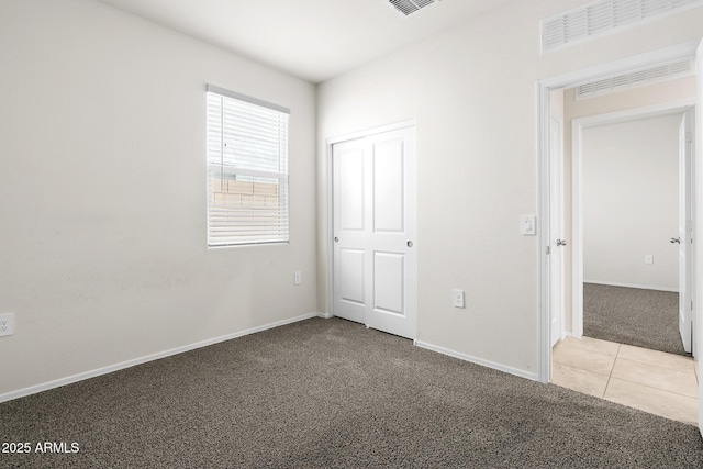 5269 E Gummite Dr, San Tan Valley, AZ 85143 - unfurnished bedroom with carpet flooring, baseboards, tile patterned floors, visible vents, and a closet