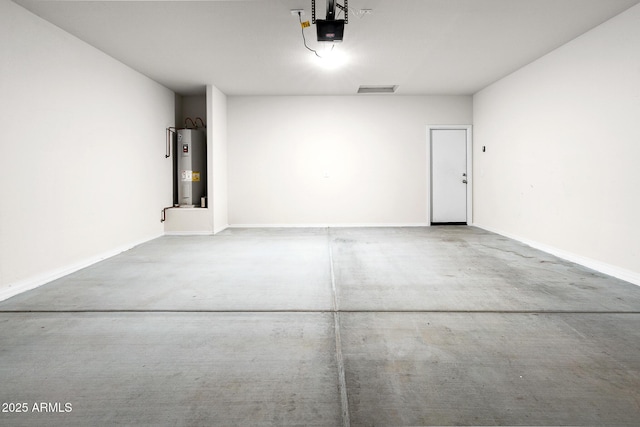 5269 E Gummite Dr, San Tan Valley, AZ 85143 - garage featuring a garage door opener, electric water heater, visible vents, and baseboards