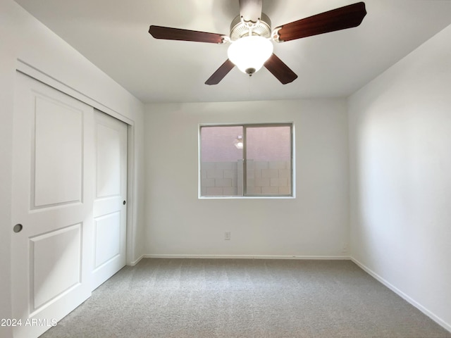 unfurnished bedroom with ceiling fan, a closet, and light carpet