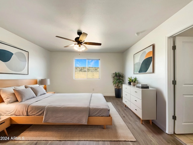 bedroom with ceiling fan and light hardwood / wood-style floors