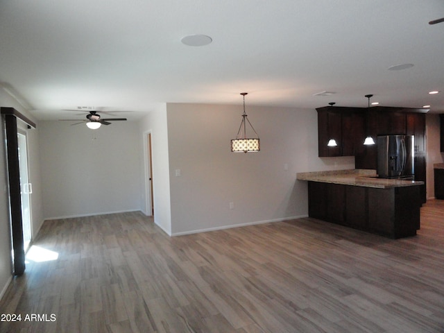 kitchen with ceiling fan, light wood-type flooring, kitchen peninsula, and stainless steel refrigerator with ice dispenser