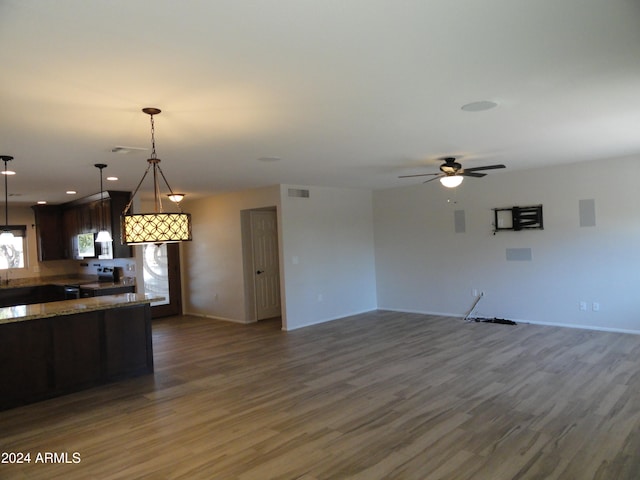 kitchen with pendant lighting, electric range, stone countertops, and dark wood-type flooring