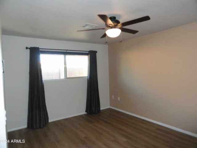 unfurnished room with ceiling fan and dark wood-type flooring