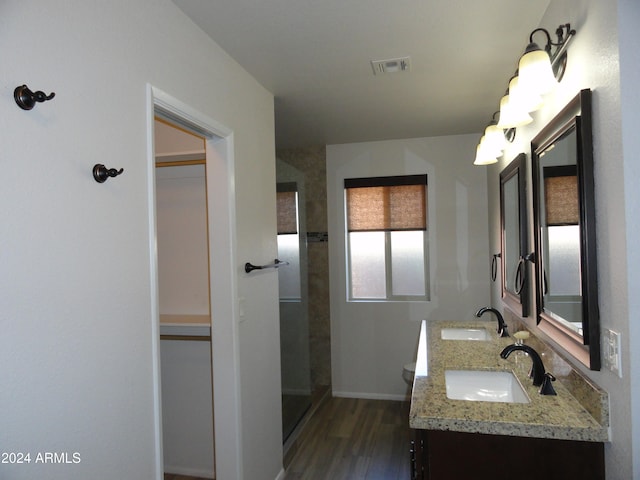 bathroom with a shower, hardwood / wood-style floors, vanity, and toilet