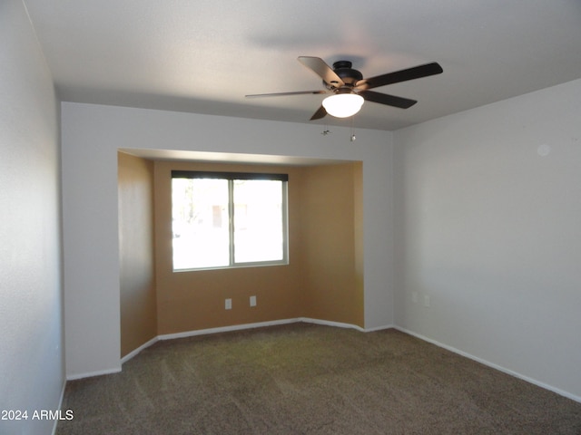 empty room with dark carpet and ceiling fan