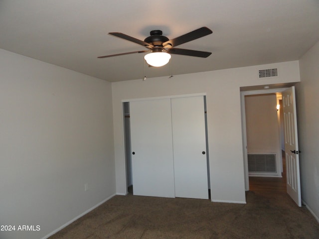 unfurnished bedroom featuring ceiling fan, a closet, and dark colored carpet