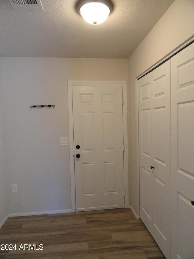 doorway with dark hardwood / wood-style flooring and a textured ceiling