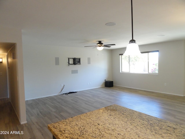 unfurnished living room featuring ceiling fan and hardwood / wood-style flooring