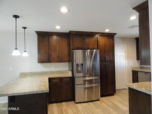 kitchen with light stone counters, dark brown cabinets, stainless steel appliances, decorative light fixtures, and light hardwood / wood-style floors