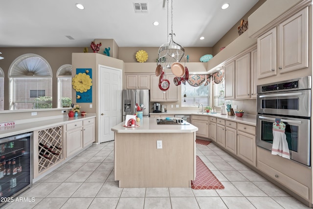 kitchen featuring appliances with stainless steel finishes, beverage cooler, light countertops, and visible vents