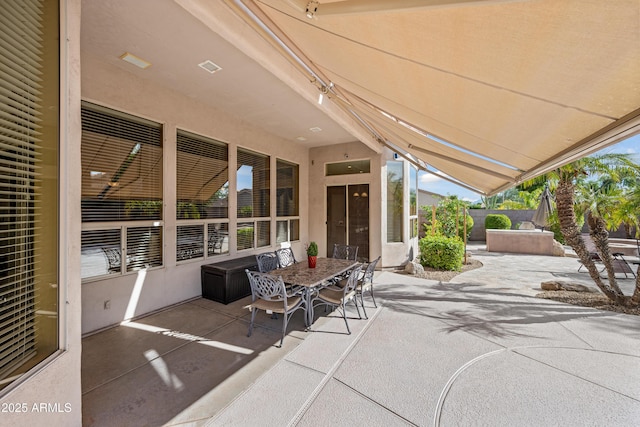 view of patio / terrace with a hot tub, visible vents, fence, and outdoor dining area