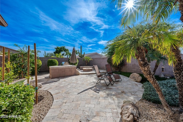 view of patio featuring an outdoor fire pit and a fenced backyard