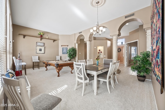 dining room featuring light colored carpet, arched walkways, visible vents, and ornate columns