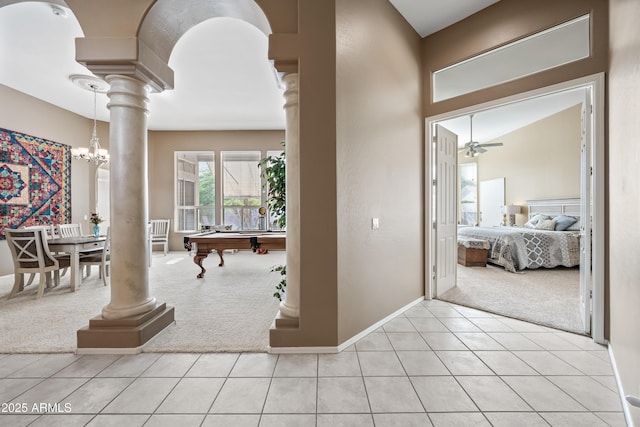 entryway with ceiling fan with notable chandelier, light carpet, ornate columns, and light tile patterned floors