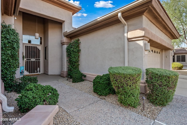 view of side of property featuring a garage and stucco siding